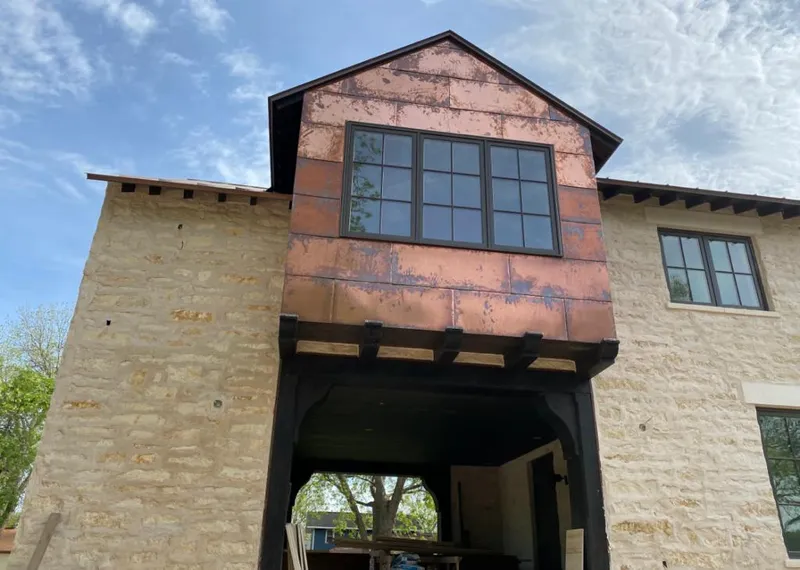 Copper metal panel facade on a stone building for Roof Repair in Sallisaw